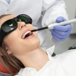 dentist using a laser treatment for whiter teeth