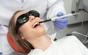 dentist using a laser treatment for whiter teeth