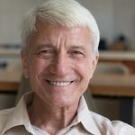 closeup of a smiling older man, new dentures